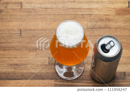 Craft beer glass with open can on wooden table 111956247