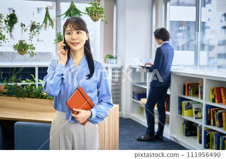 Business casual young woman calling on smartphone 111956490
