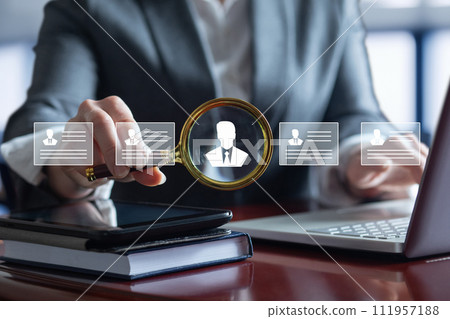 Businesswoman searches for a candidate while studying a resume . 111957188