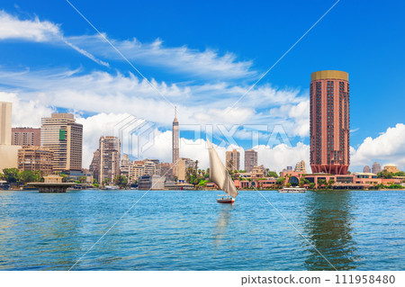 Typical sailboat in the Nile river and fancy buildings of Cairo, Egypt Typical sailboat in the Nile river and fancy buildings of Cairo, Egypt 111958480