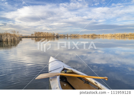 decked expedition canoe on a calm lake in northern Colorado, winter scenery without snow decked expedition canoe on a calm lake in northern Colorado, winter scenery without snow 111959128