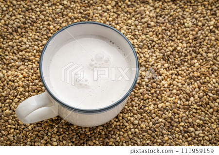 cup of hemp milk against dry hemp seed background cup of hemp milk against dry hemp seed background 111959159