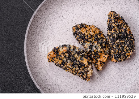 Delicious fresh crispy chicken or fish nuggets on a dark concrete background 111959529
