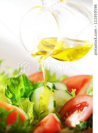 在生菜和番茄沙拉上淋上橄欖油 在生菜和番茄沙拉上淋上橄欖油 111959596