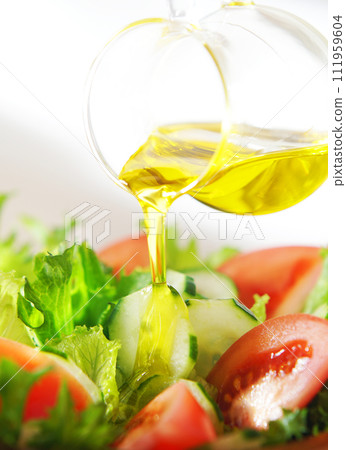 在生菜和番茄沙拉上淋上橄欖油 在生菜和番茄沙拉上淋上橄欖油 111959604