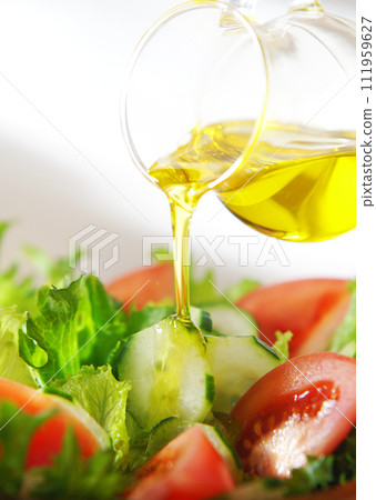 在生菜和番茄沙拉上淋上橄欖油 在生菜和番茄沙拉上淋上橄欖油 111959627