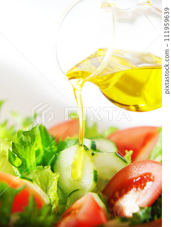 Drizzle olive oil on lettuce and tomato salad Drizzle olive oil on lettuce and tomato salad 111959639