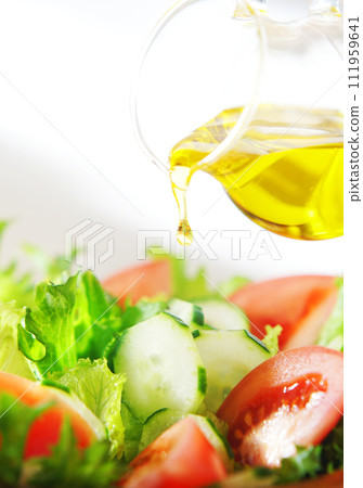 在生菜和番茄沙拉上淋上橄欖油 在生菜和番茄沙拉上淋上橄欖油 111959641