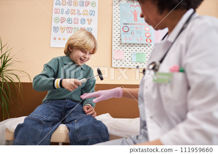 Portrait of smiling little boy having fun playing with tools in doctors office at pediatric clinic copy space Portrait of smiling little boy having fun playing with tools in doctors office at pediatric clinic copy space 111959660