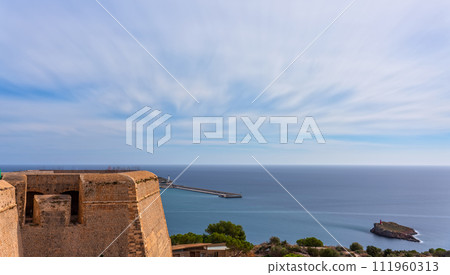 Sun Setting Over Dalt Vila Castle with Vibrant Tourist Trails in Ibiza 111960313