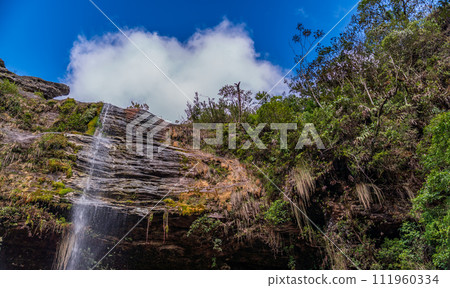 Tranquil Waterfall Flowing Down a Rocky Cliff Face Tranquil Waterfall Flowing Down a Rocky Cliff Face 111960334