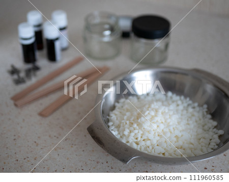 Wax in grains, wooden wicks, glass jars and essential oils for making candles at home. Hobby that can turn into a business 111960585