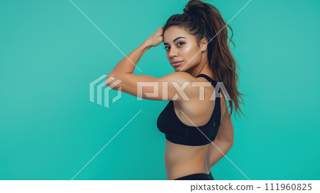 Girl fitness trainer portrait, dark black sport cloth and brown hair shows masculature isolated on solid light blue background Girl fitness trainer portrait, dark black sport cloth and brown hair shows masculature isolated on solid light blue background 111960825