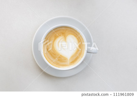 Coffee on a White Background. Coffee in a white cup with latte art. Flat lay, copy space. Cafe culture. Coffee on a White Background. Coffee in a white cup with latte art. Flat lay, copy space. Cafe culture. 111961809