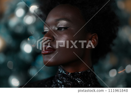 Beautiful African American woman with bright make up wears shiny silver dress 111961848