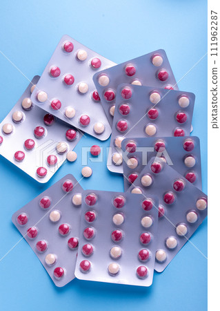Close up of a colorful pills.bicolor pills wrapped in the blister. Three tablets out of the blister. Close up of a colorful pills.bicolor pills wrapped in the blister. Three tablets out of the blister. 111962287