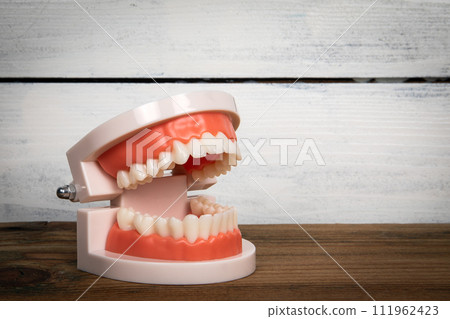 Tooth pattern on a wooden background. Healthy teeth and oral care concept Tooth pattern on a wooden background. Healthy teeth and oral care concept 111962423