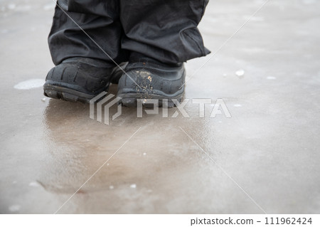 Walk with boots on the ice, close-up. Slippery roads in winter Walk with boots on the ice, close-up. Slippery roads in winter 111962424