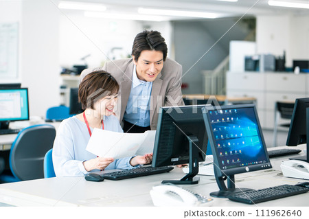 A business person who inputs to a computer while consulting with his boss A business person who inputs to a computer while consulting with his boss 111962640