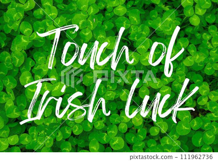Greeting card TOUCH OF IRISH LUCK text HAPPY ST PATRICKS DAY on Greenish cleaver natural background. Small green Clover leaves pattern background shamrock wallpaper holiday clovers 111962736