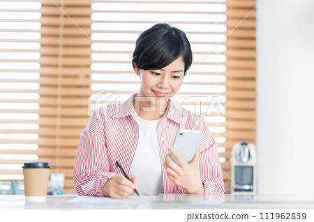 一位女士用智慧型手機學習。 111962839