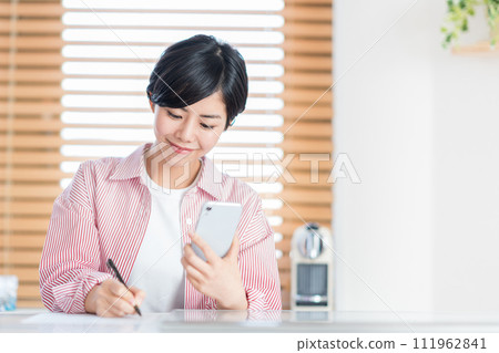 A woman studying with a smartphone. 111962841
