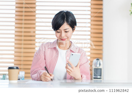 A woman studying with a smartphone. 111962842