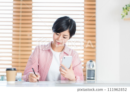 一位女士用智慧型手機學習。 111962852