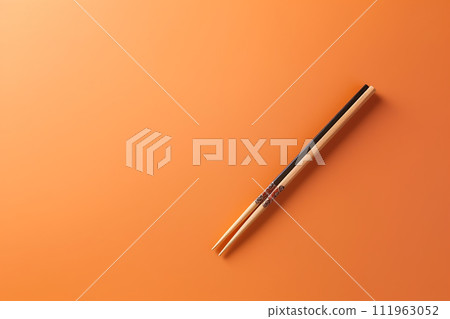Elegant Chopsticks Resting on a Vibrant Orange Background Elegant Chopsticks Resting on a Vibrant Orange Background 111963052