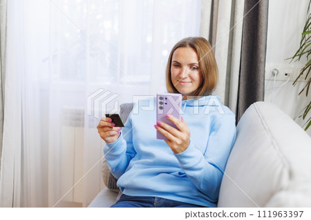 Woman holding credit card and smartphone. Woman holding credit card and smartphone. 111963397