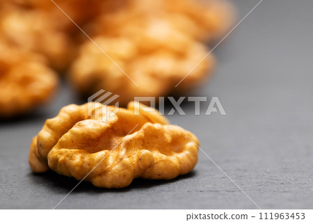 Walnuts. Walnut kernels on dark stone table. Vegetarian or healthy food 111963453