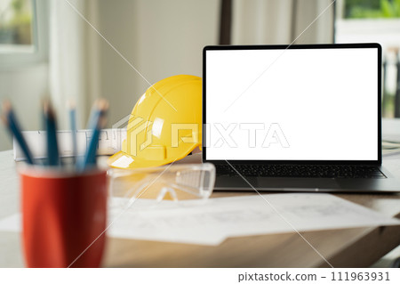 man engineer working on desktop computer with building structures in blueprints laptop white screen mockup for display man engineer working on desktop computer with building structures in blueprints laptop white screen mockup for display 111963931