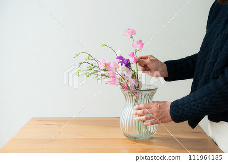 Hands of a woman arranging flowers Hands of a woman arranging flowers 111964185