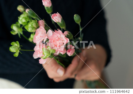 Close-up of woman's hand holding a bouquet Close-up of woman's hand holding a bouquet 111964642