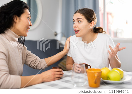Two women talking and drinking tea in apartment Two women talking and drinking tea in apartment 111964941