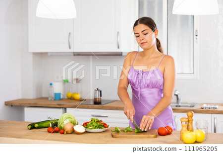 Young woman cooking salad at home Young woman cooking salad at home 111965205