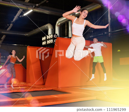 Excited young girl jumping at indoor trampoline center Excited young girl jumping at indoor trampoline center 111965299