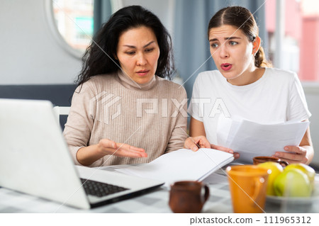 Worried LGBT couple working with papers Worried LGBT couple working with papers 111965312