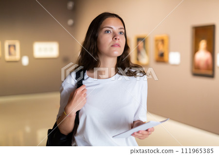 Thoughtful young girl in an art gallery studies works of art 111965385