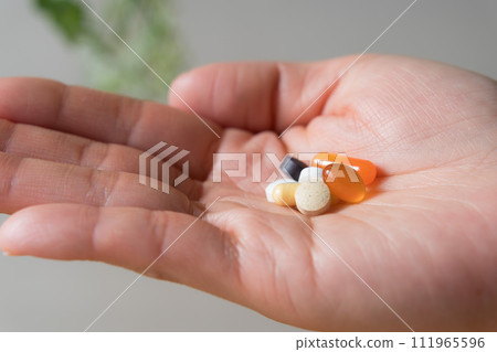 Close up of hand holding supplements 111965596