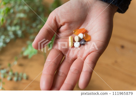 Close-up of woman's hand holding pills 111965879