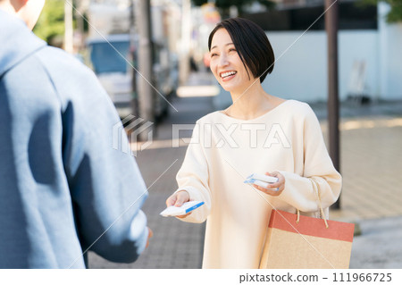 A woman handing out pocket tissues on the street A woman handing out pocket tissues on the street 111966725