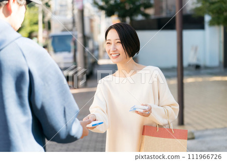 A woman handing out pocket tissues on the street A woman handing out pocket tissues on the street 111966726