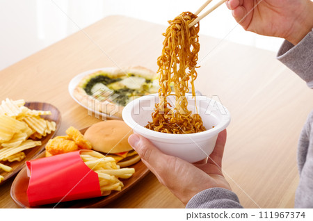 A man eating cup yakisoba 111967374