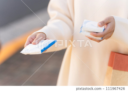A woman handing out pocket tissues on the street A woman handing out pocket tissues on the street 111967426