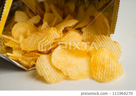 Potato chips, delicious BBQ seasoning spicy for crips, thin slice deep fried snack fast food in open bag. Potato chips, delicious BBQ seasoning spicy for crips, thin slice deep fried snack fast food in open bag. 111968270