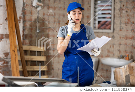 Female talking on phone at building site 111968374