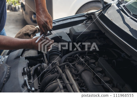 Close up Car Mechanic man hands repairing car auto repair shop. Man hands fixing machinery vehicle mechanical service. open vehicle hood checking up auto mobile. Vehicle Car maintenance engineer. Close up Car Mechanic man hands repairing car auto repair shop. Man hands fixing machinery vehicle mechanical service. open vehicle hood checking up auto mobile. Vehicle Car maintenance engineer. 111968555