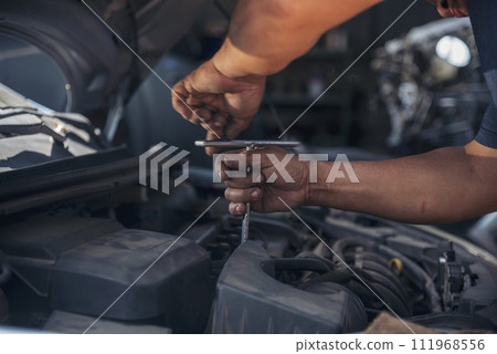 Close up Mechanic man hands repairing car auto repair shop uses jack change tyre. Man hands fixing Shock absorber machinery vehicle mechanical service. Vehicle Car overhaul maintenance engineer 111968556
