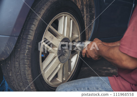 Close up Man hands fixing Shock absorber machinery vehicle mechanical service. Mechanic man hands repairing car auto repair shop uses jack change tyre. Vehicle Car overhaul maintenance engineer Close up Man hands fixing Shock absorber machinery vehicle mechanical service. Mechanic man hands repairing car auto repair shop uses jack change tyre. Vehicle Car overhaul maintenance engineer 111968558